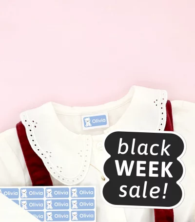 Barnskor och barnklänning med namnlappar fästa på kläderna, omgivna av snöflingedekorationer. Black Week