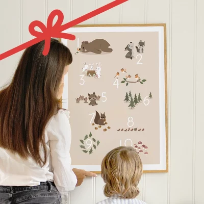 Vuxen och barn som tittar på en posters med skogsdjur på väggen.