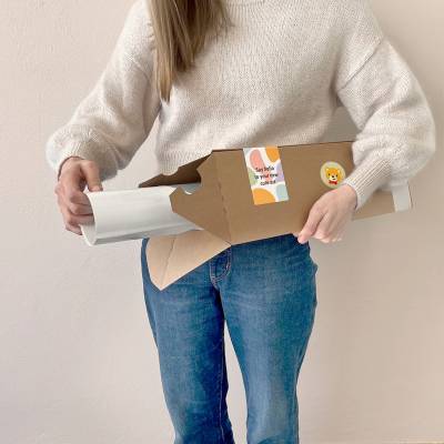 Kvinna håller en affischförpackning med barnrumsplakat.