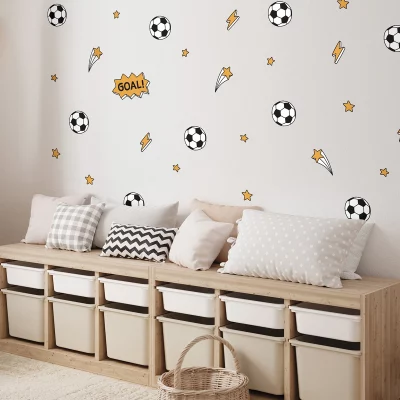 Väggdekor för barnrum med fotbollsdesign, inklusive bollar och stjärnor. En mysig sittplats med kuddar i olika mönster och färger, perfekt för lek och avkoppling. Lämplig inredning för att skapa en sportig atmosfär i rummet.