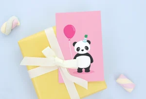 Bursdagskort med en søt panda med ballong, plassert på en gaver pakket inn i gult papir med hvitt bånd. Passer perfekt til barnebursdager.